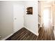 Hallway featuring modern wood-look floors, neutral paint, a utility closet, and stairway access at 1200 Ashborough Se Ter # A, Marietta, GA 30067