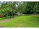 Sprawling green backyard surrounded by mature trees offers space for outdoor activities and recreation at 243 Howell Ter, Atlanta, GA 30331