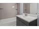 Bathroom featuring tiled walls, chrome fixtures, and an integrated tub, with modern vanity at 243 Howell Ter, Atlanta, GA 30331