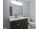 Bathroom featuring dark vanity with quartz counters, an updated mirror, and modern fixtures at 243 Howell Ter, Atlanta, GA 30331