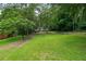 Spacious front yard leads to a charming house surrounded by lush greenery at 243 Howell Ter, Atlanta, GA 30331