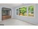 Bright living room with light-colored walls and flooring, plus a large window offering a view of the outdoor deck at 243 Howell Ter, Atlanta, GA 30331