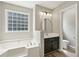 Bright bathroom with a soaking tub, glass block window, and updated vanity at 4005 Greentree Ct, Douglasville, GA 30135
