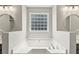 Close up of a soaking tub in the main bathroom with an obscured glass window at 4005 Greentree Ct, Douglasville, GA 30135