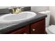 Bathroom vanity features dark countertop, golden faucet and dark-wood cabinetry at 222 Ben Ln, Fairburn, GA 30213