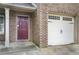 Close-up of brick-front home with garage and burgundy front door at 222 Ben Ln, Fairburn, GA 30213