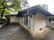 View of back patio featuring brick wall, slider and door with trees in the background at 2323 Valleyside Dr, Decatur, GA 30032