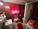 Bathroom features wood paneled walls, a sink, toilet, and shower stall with red curtains at 2323 Valleyside Dr, Decatur, GA 30032