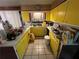 Galley kitchen with bright yellow cabinets and tile backsplash at 2323 Valleyside Dr, Decatur, GA 30032