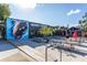 Inviting outdoor patio with picnic tables, umbrellas, and a vibrant mural creating a lively gathering space at 360 Kelly Se St, Atlanta, GA 30312