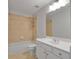Bathroom with tiled bathtub, toilet, and vanity with white countertop and cabinet at 5513 Lavender Farms Rd, Powder Springs, GA 30127