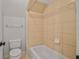 Cozy bathroom featuring a toilet and a bathtub with cream-colored tile surround at 5513 Lavender Farms Rd, Powder Springs, GA 30127