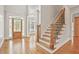 Bright foyer boasts hardwood floors, staircase with iron spindles, and detailed trim at 5513 Lavender Farms Rd, Powder Springs, GA 30127