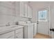 Functional laundry room with washer, dryer, sink, cabinets and wire shelving at 5513 Lavender Farms Rd, Powder Springs, GA 30127