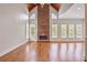 Bright living room with hardwood floors boasts a stone fireplace and large windows, adding natural light at 5513 Lavender Farms Rd, Powder Springs, GA 30127