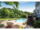 Backyard features a sparkling blue pool, lush landscaping, and a deck for relaxing and entertaining outdoors at 5513 Lavender Farms Rd, Powder Springs, GA 30127