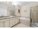 Elegant bathroom featuring a dual vanity, soaking tub, and separate glass-enclosed shower at 1184 Medlin Se St, Smyrna, GA 30080