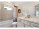 Bright bathroom features a shower-tub combo with tile surround, vanity, and large mirror at 1184 Medlin Se St, Smyrna, GA 30080