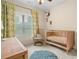 A light filled Bedroom with crib, side chair, and natural textures at 1184 Medlin Se St, Smyrna, GA 30080