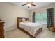 Cozy bedroom with wood bed frame, ceiling fan, and natural light from a window at 1184 Medlin Se St, Smyrna, GA 30080