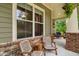 Inviting front porch featuring cozy chairs, brick accents, and views of the lush, landscaped surroundings at 1184 Medlin Se St, Smyrna, GA 30080