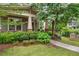 Lush front yard featuring beautiful landscaping, complemented by a charming covered porch with cozy seating at 1184 Medlin Se St, Smyrna, GA 30080