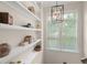 Bright hallway area with shelving, a window with blinds, and a modern light fixture at 1184 Medlin Se St, Smyrna, GA 30080