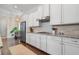 Well-lit kitchen showcasing white cabinets, granite countertops, tiled backsplash, stainless steel appliances and dark hardwood floors at 1184 Medlin Se St, Smyrna, GA 30080