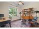 Bright office space featuring a wooden desk, stylish chair, shelving, and large window with natural light and outdoor views at 1184 Medlin Se St, Smyrna, GA 30080