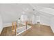Bright, neutral attic space featuring wood flooring and a charming railing, ideal for a playroom or additional living space at 1366 Allegheny Sw St, Atlanta, GA 30310
