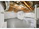 Spacious basement with exposed wood ceiling, concrete floors and walls, offering potential for customization and additional living area at 1366 Allegheny Sw St, Atlanta, GA 30310