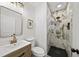 Modern bathroom featuring a marble tiled shower and a vanity with gold hardware and a neutral color palette at 1366 Allegheny Sw St, Atlanta, GA 30310