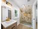 Modern bathroom features a marble tile shower, sleek vanity with gold accents, and abundant natural light for a spa-like feel at 1366 Allegheny Sw St, Atlanta, GA 30310