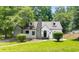 Charming home with stone chimney, white exterior, manicured lawn, and mature trees at 1366 Allegheny Sw St, Atlanta, GA 30310