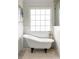 Bathroom featuring a white clawfoot tub and a large window for plenty of natural light at 178 Mayson Ne Ave, Atlanta, GA 30307