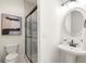 Bathroom with sleek glass shower, pedestal sink, and decorative mirror at 178 Mayson Ne Ave, Atlanta, GA 30307