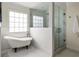 Bathroom with a clawfoot tub, tiled shower, and a large window for natural light at 178 Mayson Ne Ave, Atlanta, GA 30307