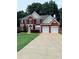 Two-story brick home with manicured lawn and two-car garage at 1991 Westover Nw Ln, Kennesaw, GA 30152