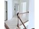Bright hallway featuring hardwood railing, carpet flooring, and views to rooms on the second floor at 1991 Westover Nw Ln, Kennesaw, GA 30152