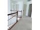 Upstairs hallway with white painted banister and multiple entry doors at 1991 Westover Nw Ln, Kennesaw, GA 30152