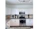 Modern kitchen featuring white cabinets, granite countertops, and stainless steel appliances at 1991 Westover Nw Ln, Kennesaw, GA 30152