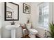 Cozy powder room with a pedestal sink, white toilet, and a bright window providing natural light at 2357 Heritage Park Nw Cir # 17, Kennesaw, GA 30144