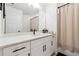 Bright bathroom with white cabinets, a large mirror, quartz countertop, and a shower with neutral colored curtain at 2357 Heritage Park Nw Cir # 17, Kennesaw, GA 30144