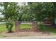Inviting entrance to Mountain Forest with brick pillars, classic lamps, and beautifully landscaped flower bed at 5488 Janice Ln, Stone Mountain, GA 30087