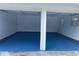 Two car garage featuring blue painted floors and paneled walls with access door on the left at 5488 Janice Ln, Stone Mountain, GA 30087