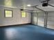 Spacious two car garage featuring blue painted floors, bright lighting and paneled walls at 5488 Janice Ln, Stone Mountain, GA 30087