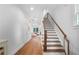 Bright foyer features hardwood floors, staircase with wood railing, and view into the living area at 1894 Dyer Cir, Atlanta, GA 30341