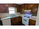 Galley kitchen with wooden cabinets and gas range at 2015 Corners Cir, Lithonia, GA 30058