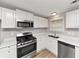 A modern kitchen with stainless steel appliances, white cabinets and countertops, and hardwood floors at 3130 Glen Knolls Ct, Alpharetta, GA 30022