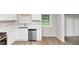A modern kitchen with stainless steel appliances, white cabinets and countertops, and hardwood floors at 3130 Glen Knolls Ct, Alpharetta, GA 30022